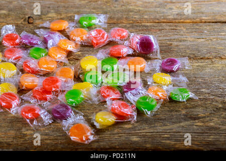 Drei verschiedene Größen von bunten Bonbons auf Holztisch. Stockfoto