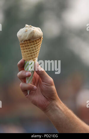 Eine Hand, die schmelzenden Eis Kegel an einem Sommerabend. Stockfoto