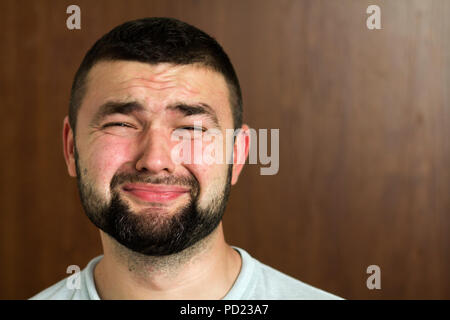 Portrait von gut aussehenden bärtigen Schwarzhaarige intelligente moderne junge Mann in Gläsern mit kurzen Haarschnitt und eine Art schwarze Augen lächelnd auf unscharfen Hintergrund Stockfoto