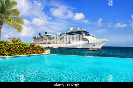 Blick vom Pool im Tropical Resort auf Kreuzfahrt Schiff angedockt am Port Stockfoto