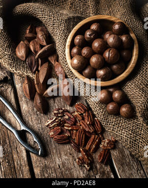 Macadamia, Pecan und Pili Muttern auf Holztisch. Stockfoto