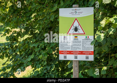 Warnschild "Warnung tick Bereich" in einem Naturpark von Südtirol, Italien - Trentino Alto Adige. Stockfoto