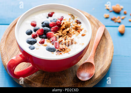 Natürliche Joghurt mit Honig Müsli-, Granatapfel- und Heidelbeeren in eine Schüssel, Detailansicht Stockfoto