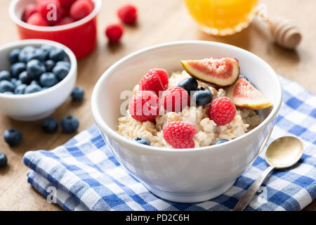 Haferflocken Porridge mit Himbeeren, Heidelbeeren und Feigen. Gesundes Frühstück zu essen. Colofrul Frühstück auf einem Tisch Stockfoto