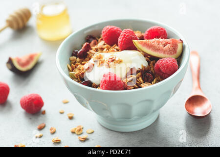 Gesundes Frühstück oder Imbiss Müsli mit Joghurt, Himbeeren, Feigen in eine Schüssel geben. Detailansicht, getönten Bild. Konzept der gesunden Lebensweise, gesunde Ernährung, Stockfoto