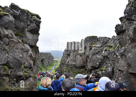 Touristen gehen Sie die tektonischen Bruch zwischen der nordamerikanischen und der eurasischen Platte in Thingvellir, Island. Juli, 2018 Stockfoto