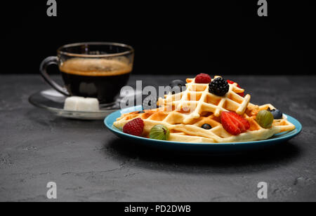 Foto Tasse schwarzen Kaffee mit Zucker mit Wiener Waffeln mit Erdbeeren, Himbeeren Stockfoto