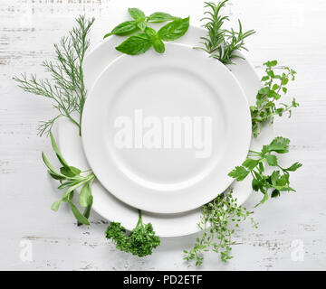 Leeren Teller mit Kräutern auf hölzernen Tisch Stockfoto