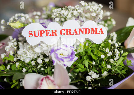 Wunderschöne Blumen auf verschwommenen Hintergrund. Blumenstrauß aus weiß und lila Blüten. Glückliche Großeltern-Tag. Grußkarte. Super Großmutter. Stockfoto