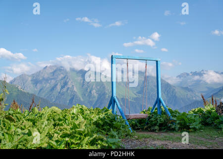 Die alten hölzernen Schaukel für Kinder im Hof. gegen Berg Stockfoto