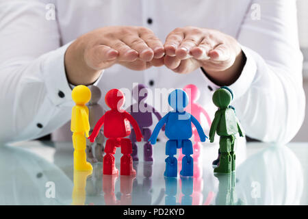 Ist eine Person, die schützende Hand mit menschlichen Figuren bilden Kreis Stockfoto