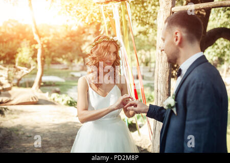 Beauty Braut und Bräutigam sind stattlich tragen Ringe. Hochzeit paar auf der Eheschließung. Schönes Modell Mädchen in weißem Kleid. Mann in Sui Stockfoto