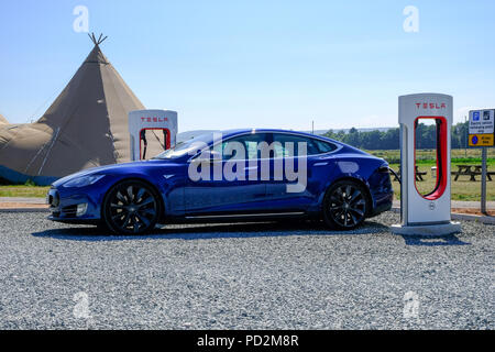 Bath, Devon, Großbritannien. Tesla Model S laden zu einem Tesla Kompressor station in Dart Farm Stockfoto