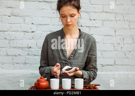 Junge Frau, die in der Meditation sitzen Posieren vor Tee und Aroma Sticks. Entspannung Konzept. Stockfoto