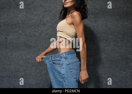 Schlanke Mädchen mit Übergröße Hosen Stockfoto