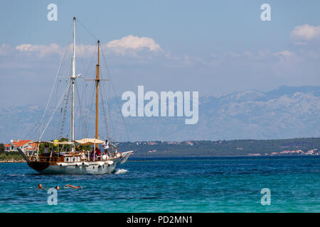 Zadar, Kroatien - 24. Juli 2018: Menschen schwimmen im transparenten Gewässern der Insel Ugljan Stockfoto