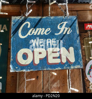 Altmodische, retro, Vintage" kommen wir öffnen' verblasst, scratch Schild hängen an einem Pub, Café Fenster. Close Up, Quadrat. Stockfoto