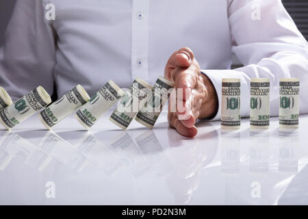 Der Geschäftsmann Hand anhalten, bis Banknoten auf weißem Schreibtisch gerollt Stockfoto