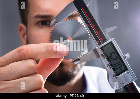 Close-up von der Größe eines Menschen Hand Messgetriebe mit digitalen elektronischen Messschieber Stockfoto