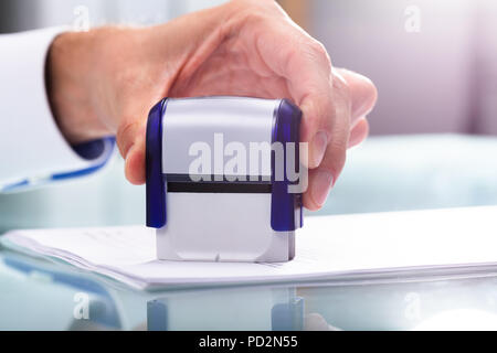In der Nähe von einem Geschäftsmann Hand Stanzen Genehmigt auf Dokument Stockfoto