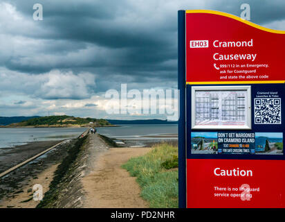 Gezeiten Causeway mit dem Zweiten Weltkrieg konkrete Schiff Barriere zu Cramond Insel mit Hinweis über Sicherheit und Gezeiten, Cramond, Edinburgh, Schottland, Großbritannien Stockfoto