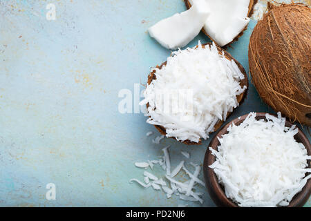 Kokosraspeln in einer Shell auf einem blauen Hintergrund. Ansicht von oben mit der Kopie. Stockfoto