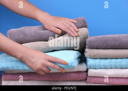 Ein studio Konzept Foto von weiblichen Händen erreichen für ein gefaltetes Handtuch. Stockfoto