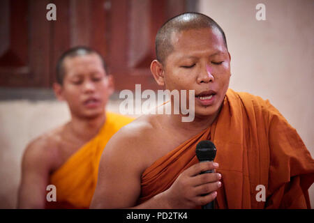 Ein buddhistischer Mönch singen mit seinen Augen während einer Zeremonie in einem der Tempel in ihrem Kloster geschlossen. Stockfoto