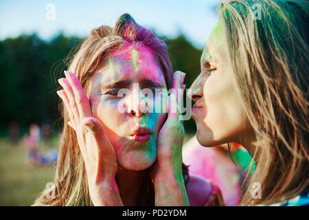 Zwei junge Frauen mit Gesichtern in farbige Kreide Pulver im Holi Festival abgedeckt Stockfoto