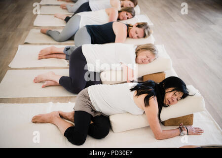 Frauen in Entspannung Pose nach Yoga Klasse bei Rückzug Stockfoto