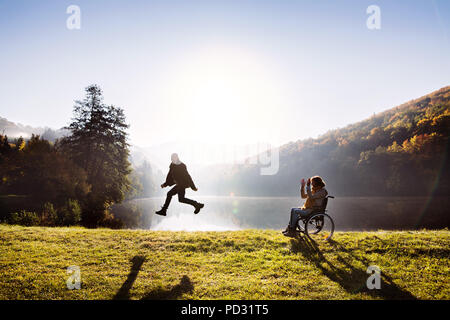 Senior Paar mit Rollstuhl im Herbst Natur. Stockfoto