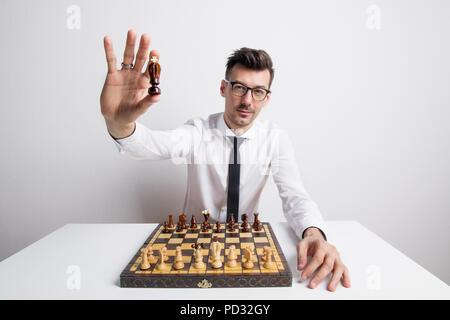 Porträt eines jungen Mannes in einem Studio, Schach spielen und halten ein König weiße Ritter. Stockfoto