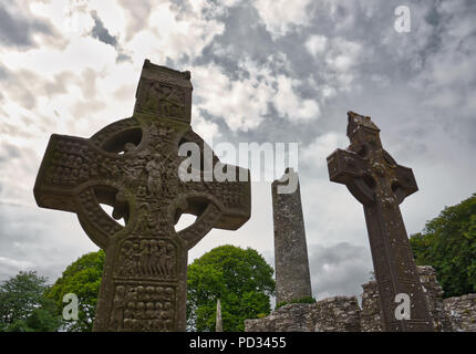 Zwei sehr hohen Sandstein Kreuze auf dem Friedhof mit dem berühmten runden Turm von monasterboice im Hintergrund Stockfoto