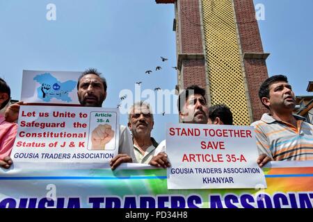 August 5, 2018 - Srinagar, J&K, Indien - Mitglieder von Kaschmir, Händler und Hersteller von Föderation (KTMF) gesehen Plakate während des Protestes. Leben im Kaschmir-tal kam zum Stillstand aufgrund einer vollständigen Abschaltung gemäß der Gemeinsamen Widerstand Führung (JRL) gegen die rechtliche Herausforderung in das Oberste Gericht über die Gültigkeit von Artikel 35 -, die die Menschen Bars außerhalb von Jammu und Kaschmir vom Erwerb von Immobilienbesitz im Staat. Händler Sie am historischen Uhrturm in Lal Chowk '' rechtliche Ansturm'' auf der Artikel 35 - A. Protest Demonstranten mit Plakaten sh Stockfoto