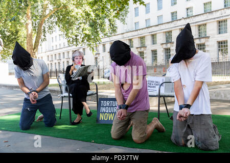 London, UK, 6. August 2018. Amnesty International UK Stunt. Aktivist in Theresa May Maske angezeigt wird, ignorieren drei Folter 'Opfer' in Stunt Hervorhebung Anruf Mitkämpfer" für die Untersuchung der Beteiligung Großbritanniens an Folter. Unmittelbar nach dem Stunt, Amnestie, Begnadigung, der Freiheit und der Freiheit von Folter übergeben eine 27.000 Mann starke Petition in 10 Downing Street mit einer formalen Forderung nach einer Folter Anfrage. c opyright Carol Moir/AlamyLiveNews Stockfoto