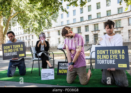 London, Großbritannien. 6. August 2018. Ein Aktivist von Amnesty International UK das Tragen eines Theresa May Maske Getränke Tee Außerhalb der Downing Street und dabei drei Opfer von Folter als Teil einer Protestbewegung, die für eine unabhängige, Richter - LED-Anfrage in Einbeziehung des Vereinigten Königreichs in die Folter von Gefangenen in Übersee. Eine Petition wurde auch an 10 Downing Street von Amnesty Kate Allen, Direktor der britischen, Simone Abel von Reprieve, Sam Grant der Freiheit und Sonya Sceats der Freiheit von Folter dargestellt). Credit: Mark Kerrison/Alamy leben Nachrichten Stockfoto