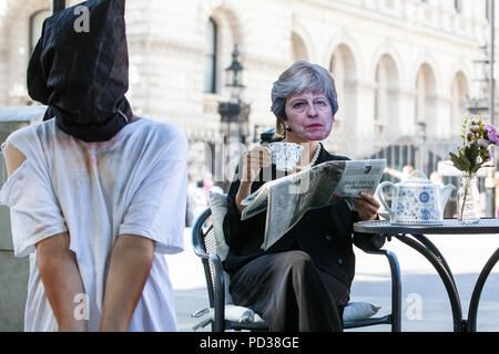 London, Großbritannien. 6. August 2018. Ein Aktivist von Amnesty International UK das Tragen eines Theresa May Maske Getränke Tee Außerhalb der Downing Street und dabei ein Opfer von Folter als Teil einer Protestbewegung, die für eine unabhängige, Richter - LED-Anfrage in Einbeziehung des Vereinigten Königreichs in die Folter von Gefangenen in Übersee. Eine Petition wurde auch an 10 Downing Street von Amnesty Kate Allen, Direktor der britischen, Simone Abel von Reprieve, Sam Grant der Freiheit und Sonya Sceats der Freiheit von Folter dargestellt). Credit: Mark Kerrison/Alamy leben Nachrichten Stockfoto