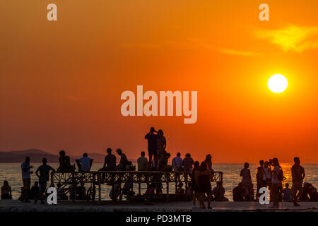 Zadar, Kroatien - 24. Juli 2018: Leute, die einen eindrucksvollen Sonnenuntergang von einem Dock in der Altstadt von Zadar Stockfoto