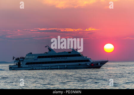 Zadar, Kroatien - 24. Juli 2018: Boot übersetzende Passagiere bei Sonnenuntergang in Zadar Stockfoto