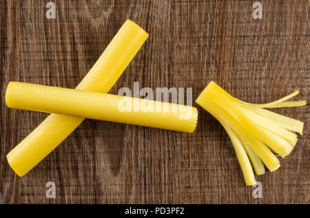 Gruppe von zwei ganzen ein Stück geräucherte slowakischen String Käse stick flatlay auf braunem Holz Stockfoto