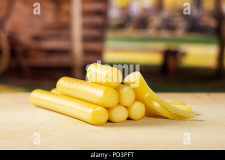 Menge ganze ein Stück geräucherte slowakischen String Käse Stick mit Karre im Hintergrund Stockfoto
