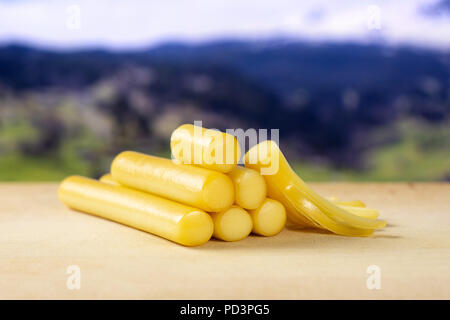 Menge ganze ein Stück geräucherte slowakischen String Käse Stick mit Sommer Alpen im Hintergrund Stockfoto