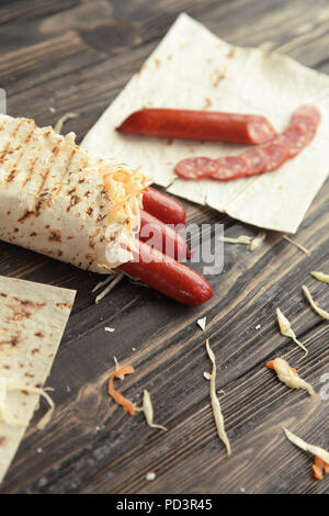 Geräucherte Wurst in pita Brot auf einem Holztisch Stockfoto