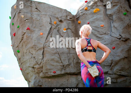 Foto von der Rückseite der sportlichen weiblichen Kletterer mit Tasche von Seife gegen rock Boulder Stockfoto