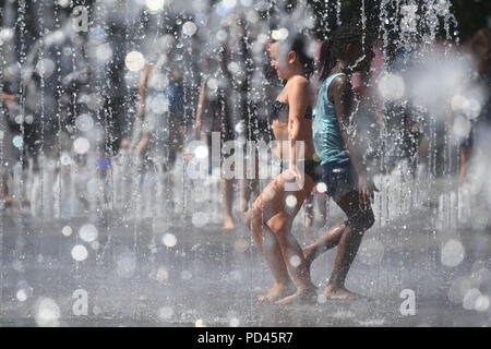 Kinder spielen in den Brunnen am Getreidespeicher Square, King's Cross, London. Stockfoto