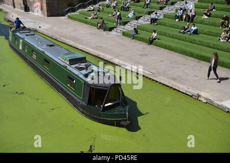 Ein Kanal Boot führt entlang des Regent's Canal in der Kornkammer Square in King's Cross, London. Stockfoto