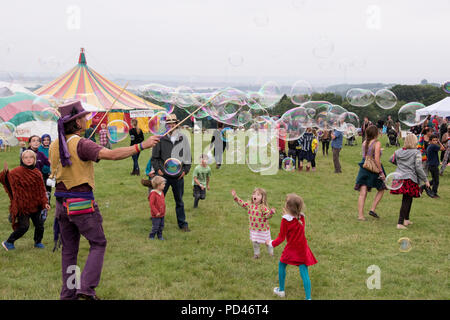 Newport, Wales - 23 Aug 14: Bubblemen am Arbeitsplatz - Mann schafft riesige Blasen für eine Masse von Kindern für Kinder mit Spielen und 14 Aug 2015 Pop an der Gr Stockfoto