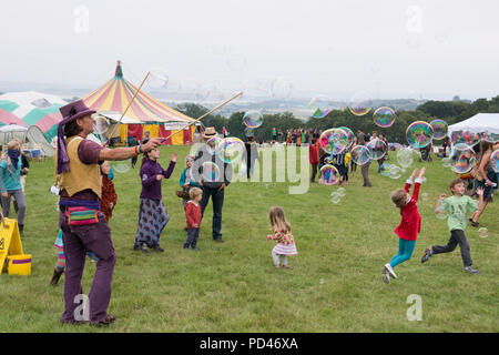 Newport, Wales - 23 Aug 14: Bubblemen am Arbeitsplatz - Mann schafft riesige Blasen für eine Masse von Kindern für Kinder mit Spielen und 14 Aug 2015 Pop an der Gr Stockfoto