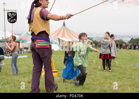 Newport, Wales - 23 Aug 14: Bubblemen am Arbeitsplatz - Mann schafft riesige Blasen für eine Masse von Kindern für Kinder mit Spielen und 14 Aug 2015 Pop an der Gr Stockfoto