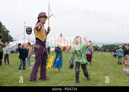 Newport, Wales - 23 Aug 14: Bubblemen am Arbeitsplatz - Mann schafft riesige Blasen für eine Masse von Kindern für Kinder mit Spielen und 14 Aug 2015 Pop an der Gr Stockfoto